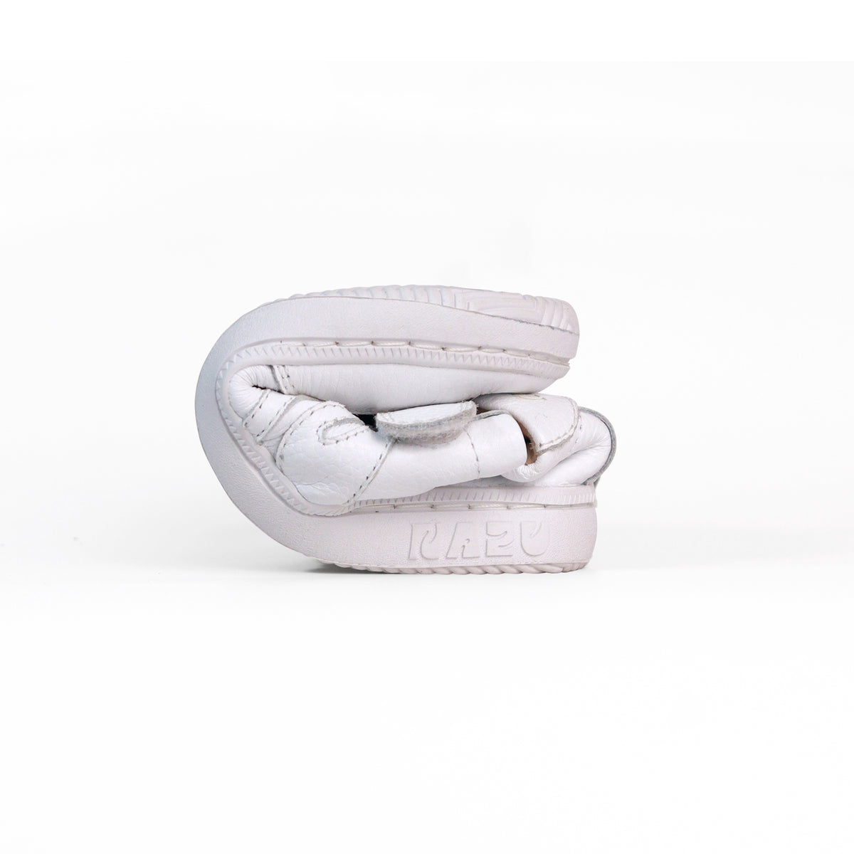 Zapatilla barefoot Noa doblada, muestra su suela flexible
